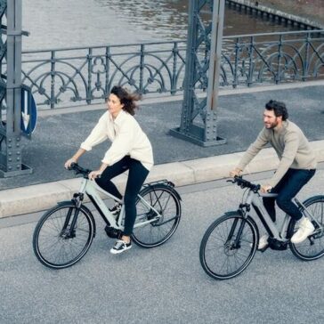 twee-ebikes-man-vrouw-fietsen-op-brug