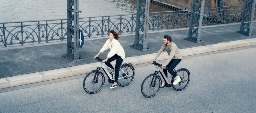 twee-ebikes-man-vrouw-fietsen-op-brug